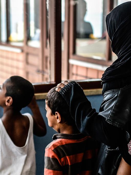 Eine Syrerin wartet in Istanbul mit Kindern auf eine Fähre