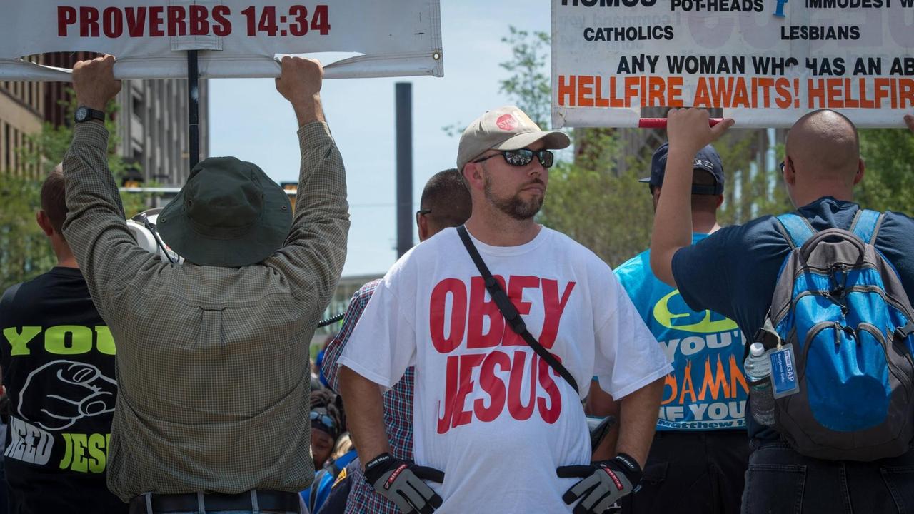Christliche Demonstranten protestieren am 20. Juli 2016 vor der Repulican National Convention in Cleveland Ohio - im Zentrum steht ein junger Mann, sein T-Shirt trägt die Aufschrift "Obey Jesus" - "Gehorche Jesus". Die Plakate drohen unter anderem Frauen, die einen Schwangerschaftsabbruch vornehmen lassen, mit dem Höllenfeuer.
