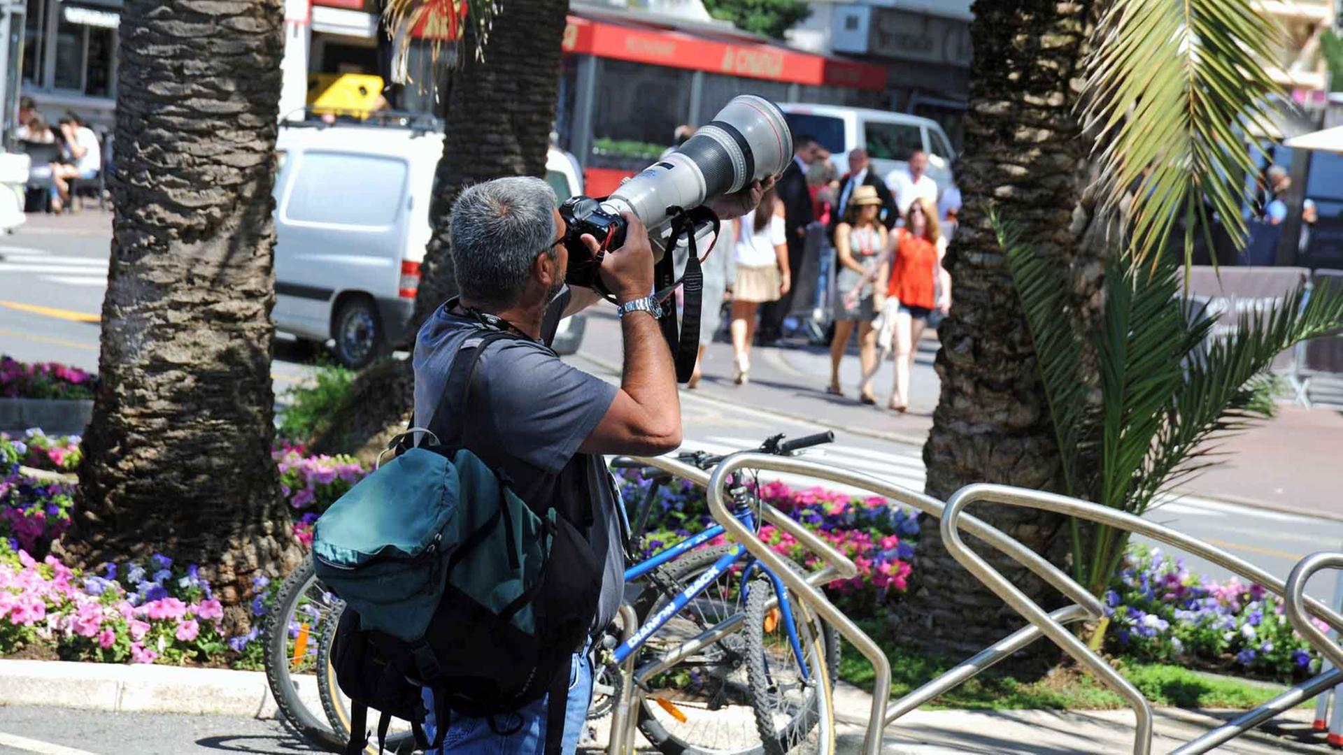 Ein Paparazzo fotografiert ein Starlet in Cannes.