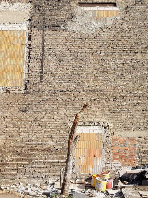 Die Brandmauer eines alten Wohnhause in Berlin-Pankow im Bereich der ehemaligen Mauer, die bei Renovierungsarbeiten freigelegt wurde und Spuren früherer Anbauten zeigt.
