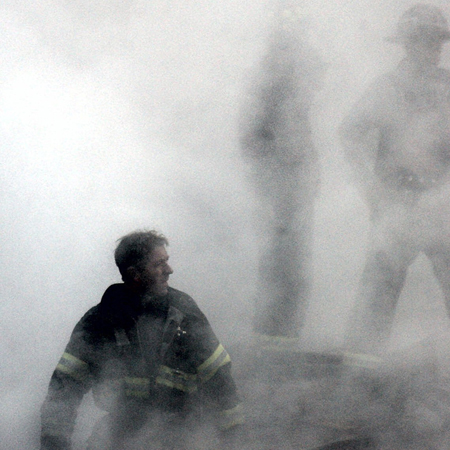 Ein Feuerwehrmann nach dem Einsturz des World Trade Centers zwischen Rauch und Trümmern zu sehen