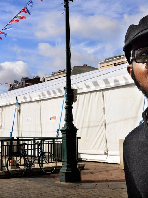 Der Schriftsteller, Essayist und Fotograf Teju Cole vor einer urbanen Kulisse