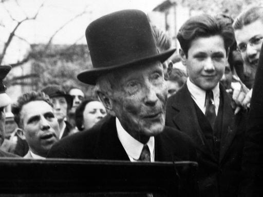 Umringt von Schaulustigen steigt der amerikanische Industrielle und Milliardär John Davison Rockefeller nach einem Gottesdienstbesuch am 14.5.1933 in Lakewood in New Jersey in seinen Wagen.