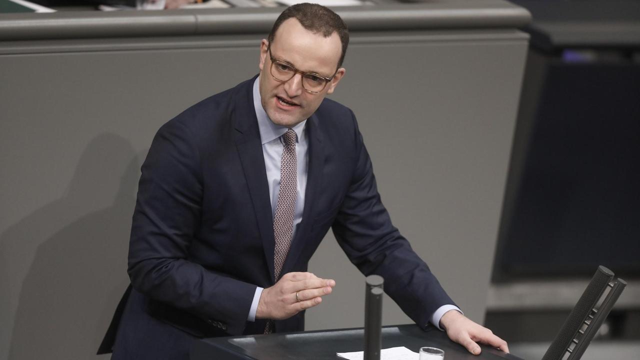 Gesundheitsminister Spahn steht im Bundestag hinter einem Rednerpult.