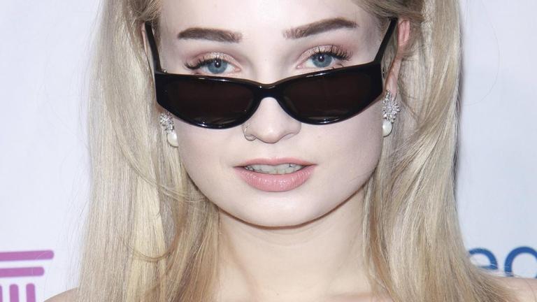 Popstar Kim Petras schaut lässig über ihre Sonnenbrille