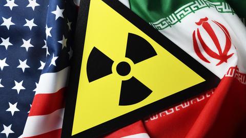 Eine Bildkollage auf der die Fahnen der USA und des Iran sowie ein Radioaktivitätwarnschild zu sehen sind.