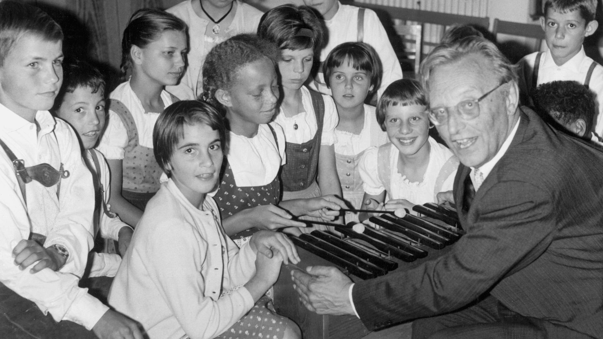 Der deutsche Komponist Carl Orff ("Carmina Burana") zeigt Kindern des SOS-Kinderdorfes in Dießen am Ammersee am 28.9.1964 das Musizieren mit einem Xylophon.