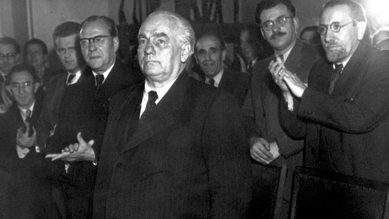 Mehrer Männer applaudieren Wilhelm Pieck nach seiner Wahl zum Präsidenten der DDR.