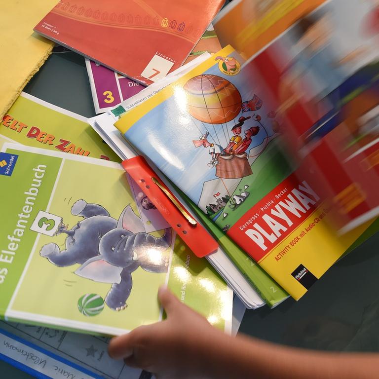 Eine Grundschülerin sortiert ihre Schulbücher