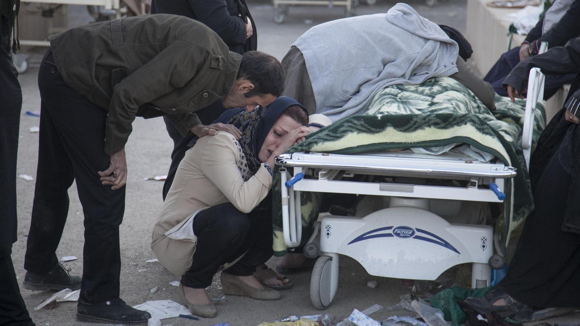Iranians mourn over the body of a victim following a 7.3-magnitude earthquake in Sarpol-e Zahab in Iran's western province of Kermanshah on November 13, 2017. / AFP PHOTO / TASNIM NEWS / Farzad MENATI