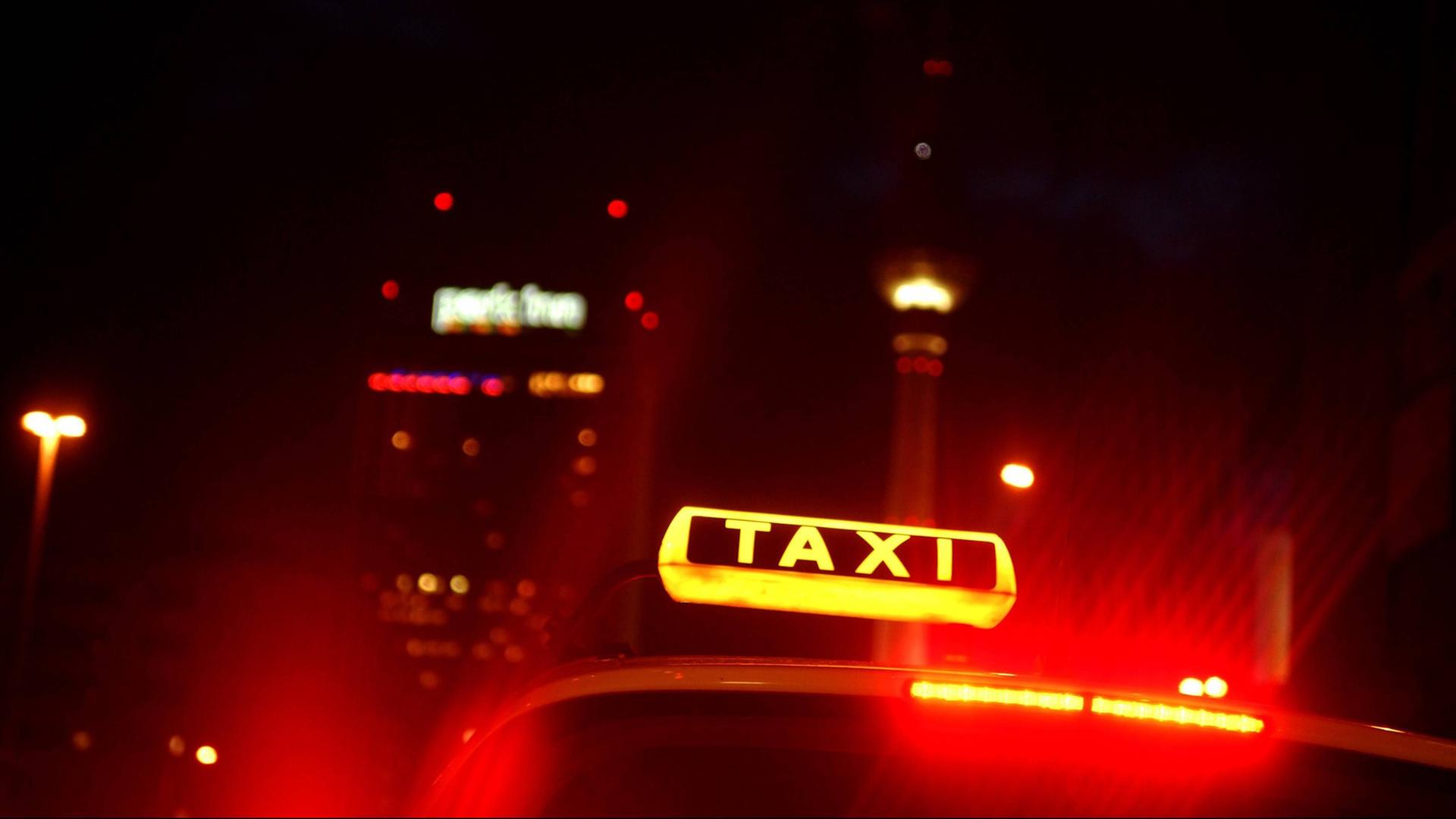 Eine nächtliche Restlichtaufnahme eines Taxischildes in Berlin, Deutschland 2009. Im Hintergrund sind ist der Fernsehturm zu erkennen.