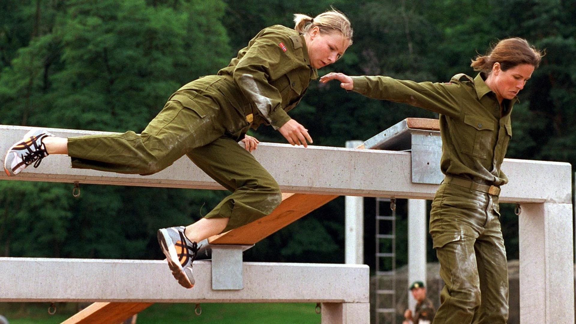 Die norwegischen Reservistinnen Elin Jörgensen (l) und Anne Dugstad überwinden am 2.8.2000 in Berlin beim internationalen CIOR-Militärwettkampf der Reserveoffiziere der NATO-Mitgliedsstaaten und befreundeter Länder eine Balkentreppe auf der Hindernisbahn.