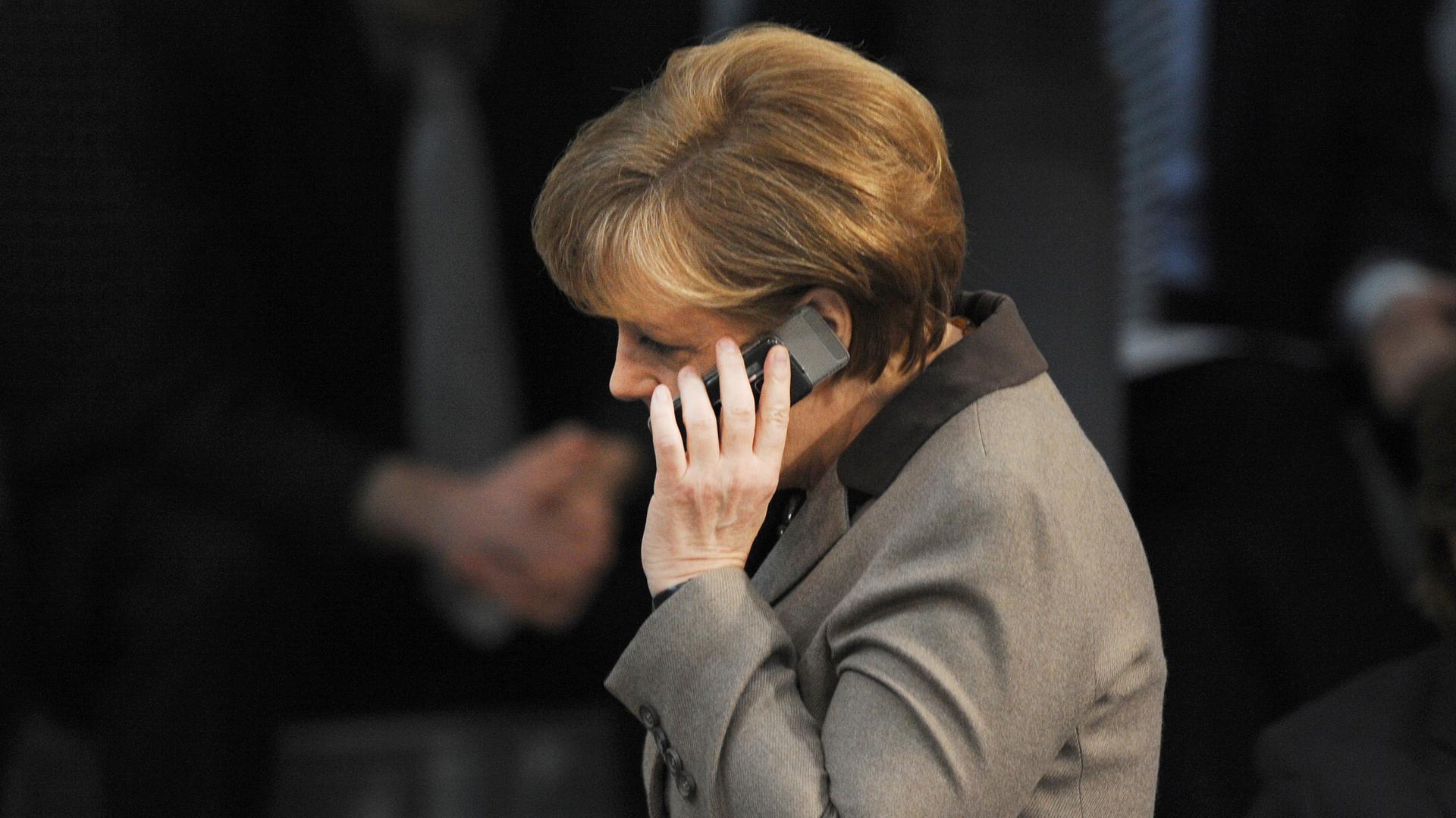 Mit einem Handy am Ohr geht Bundeskanzlerin Angela Merkel (CDU) am Donnerstag (29.03.2012) durch den Plenarsaal des Bundestages in Berlin. Der erste Tagespunkt ist der Europäische Stabilitätsmechanismus und Fiskalpakt. Weiter Themen sind der Infrastruktur Mit einem Handy am Ohr geht Bundeskanzlerin Angela Merkel (CDU) am Donnerstag (29.03.2012) durch den Plenarsaal des Bundestages in Berlin. Der erste Tagespunkt ist der Europäische Stabilitätsmechanismus und Fiskalpakt. Weiter Themen sind der Infrastruktur