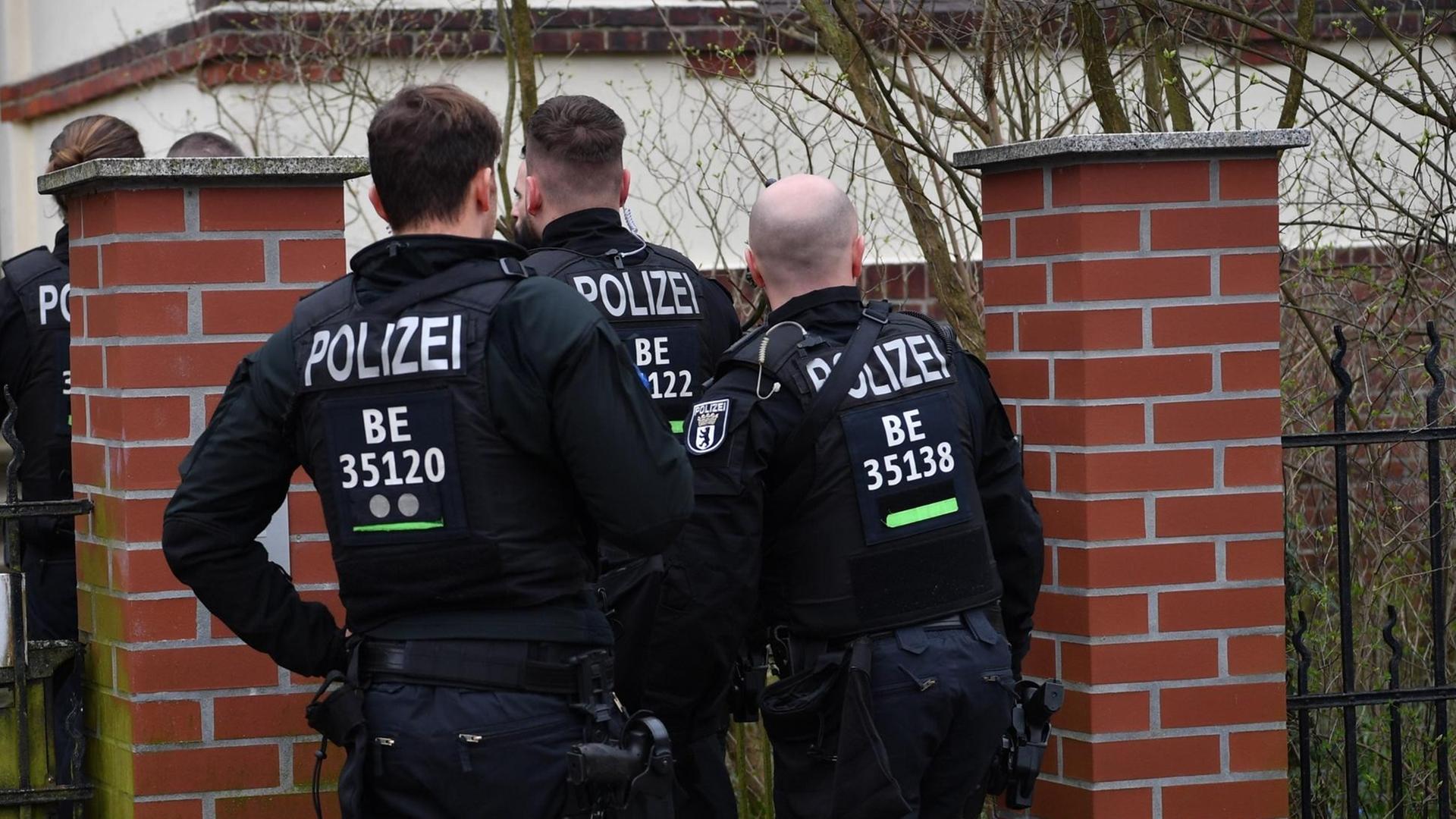 Polizisten stehen während einer Wohnungs-Razzia an einem Tor zu einem Haus. Nach dem Verbot der Reichsbürgergruppe «Geeinte deutsche Völker und Stämme» fanden in mehreren Bundesländern Razzien statt.
