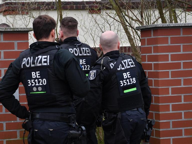 Polizisten stehen während einer Wohnungs-Razzia an einem Tor zu einem Haus. Nach dem Verbot der Reichsbürgergruppe «Geeinte deutsche Völker und Stämme» fanden in mehreren Bundesländern Razzien statt.