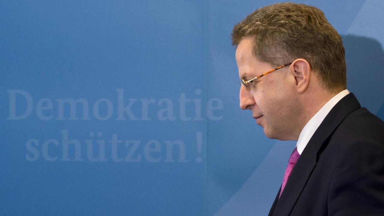 Hans-Georg Maaßen im seitlichen Profil, im Hintergrund steht "Demokratie schützen!"