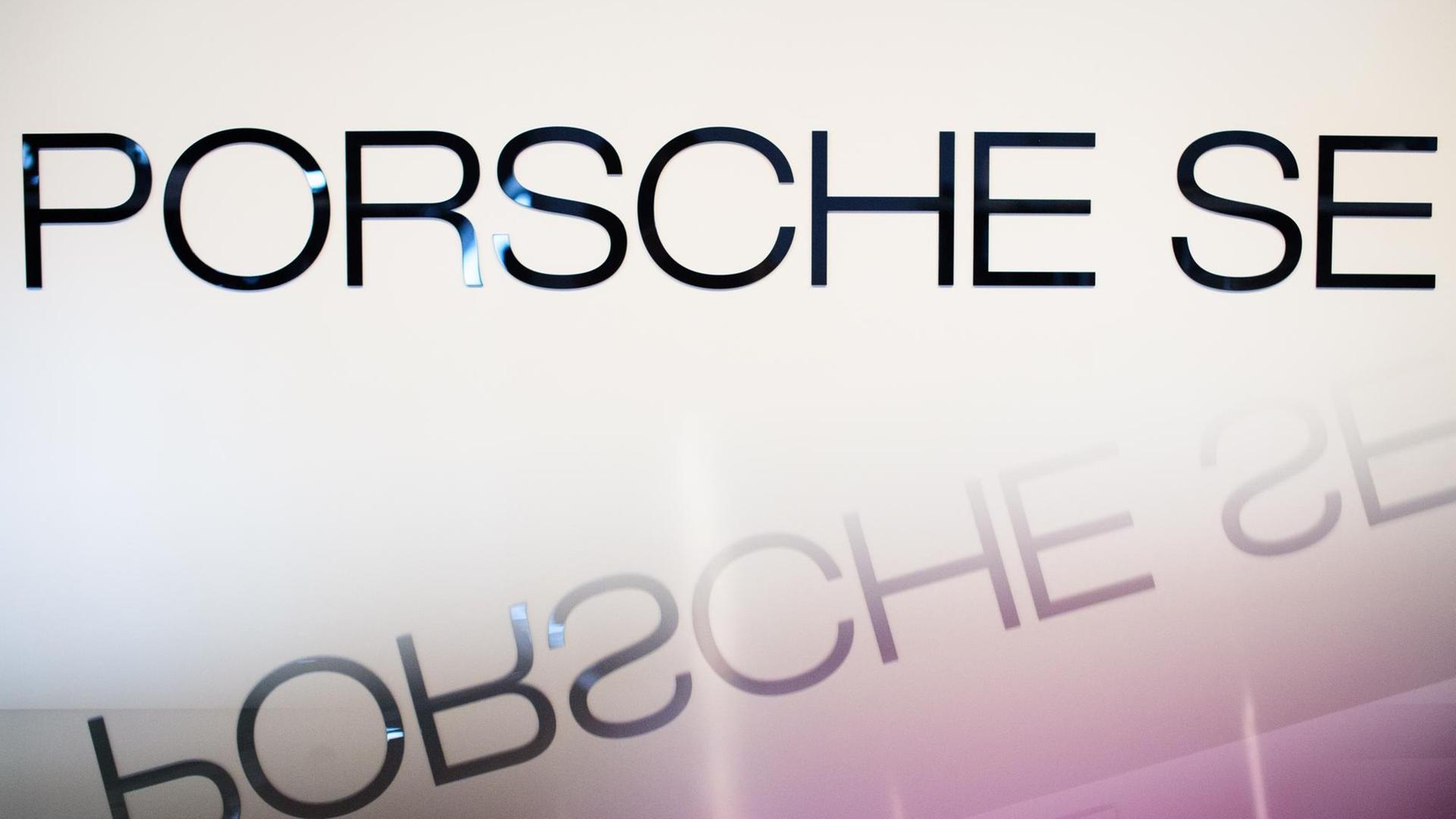 Der Schriftzug "Porsche SE" spiegelt sich auf einer glatten Oberfläche.