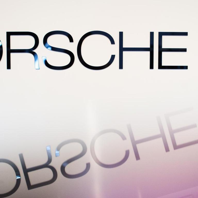 Der Schriftzug "Porsche SE" spiegelt sich auf einer glatten Oberfläche.
