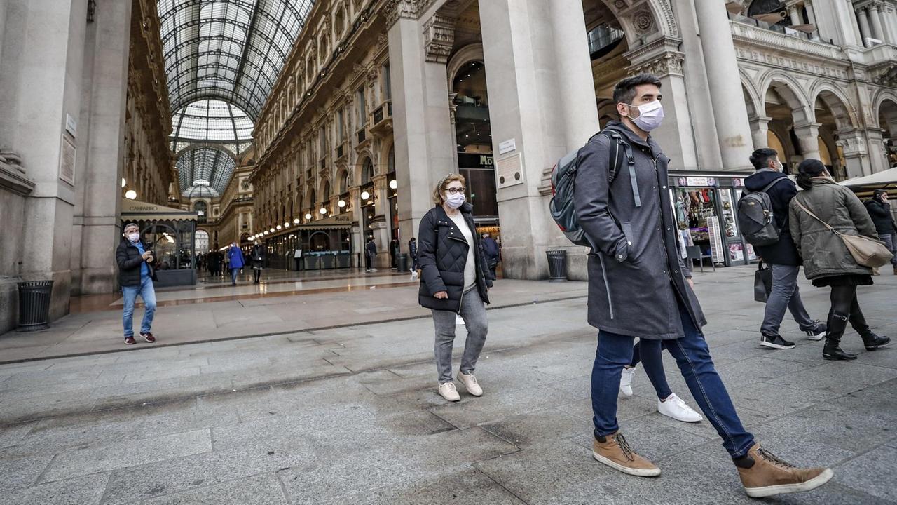 In Italien wollen sich Menschen mit Masken vor dem Virus schützen.