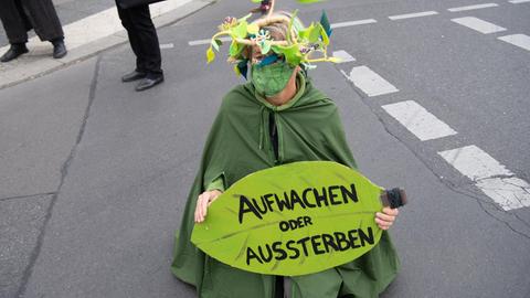 05.10.2020, Berlin: Eine Umweltaktivistin hält während einer Demonstration unter dem Motto «Trauerzug der toten Bäume» von Extinction Rebellion (XR) unweit des Bundeslandwirtschaftsministeriums ein Schild mit der Aufschrift «Aufwachen statt Aussterben». Für diese Woche hat Extinction Rebellion Protestaktionen gegen Umweltzerstörung und Klimawandel angekündigt. Foto: Paul Zinken/dpa