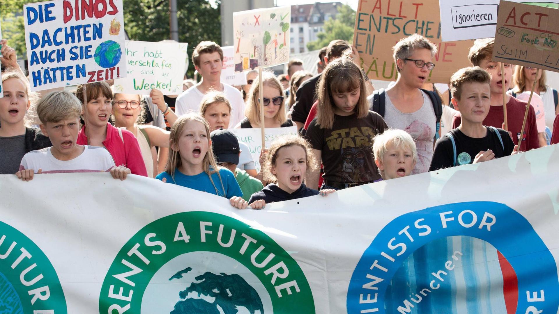 Menchen tragen auf einer Demo ein großes Transparent. Darauf steht "Parents 4 future" und "Scientists 4 future".