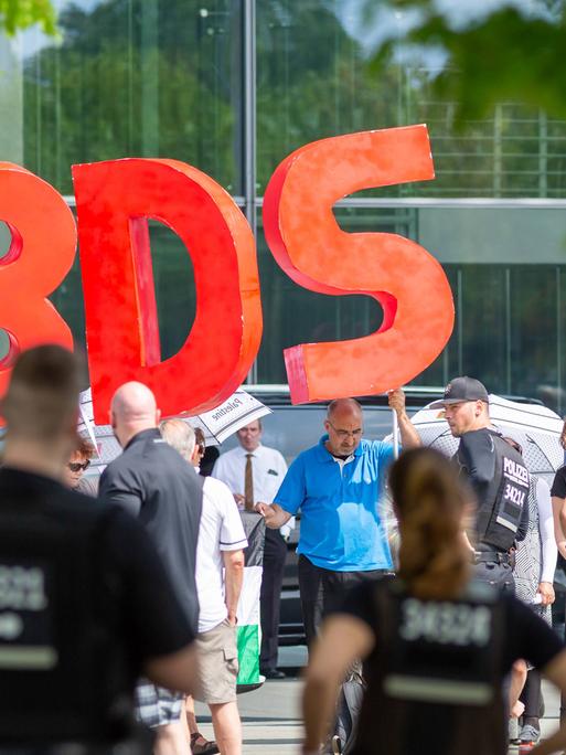 Die Buchstaben BDS - für Boycott, Divestment and Sanctions - werden von Demonstranten hochgehalten, die anlässlich des Besuchs des israelischen Ministerpräsidenten Benjamin Netanjahu im Bundeskanzerlamt in Berlin im Juni 2018 protestierten