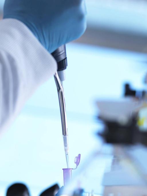 Ein Wissenschaftler nimmt per Pipette eine DNA-Probe