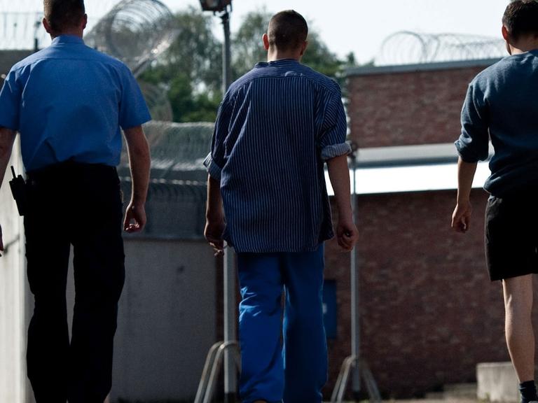 Zwei Gefangene gehen am 18.09.2012 in Betreuung eines Justizangestellten über das Gelände der Untersuchungs- und Jugendhaftanstalt Berlin-Tegel.