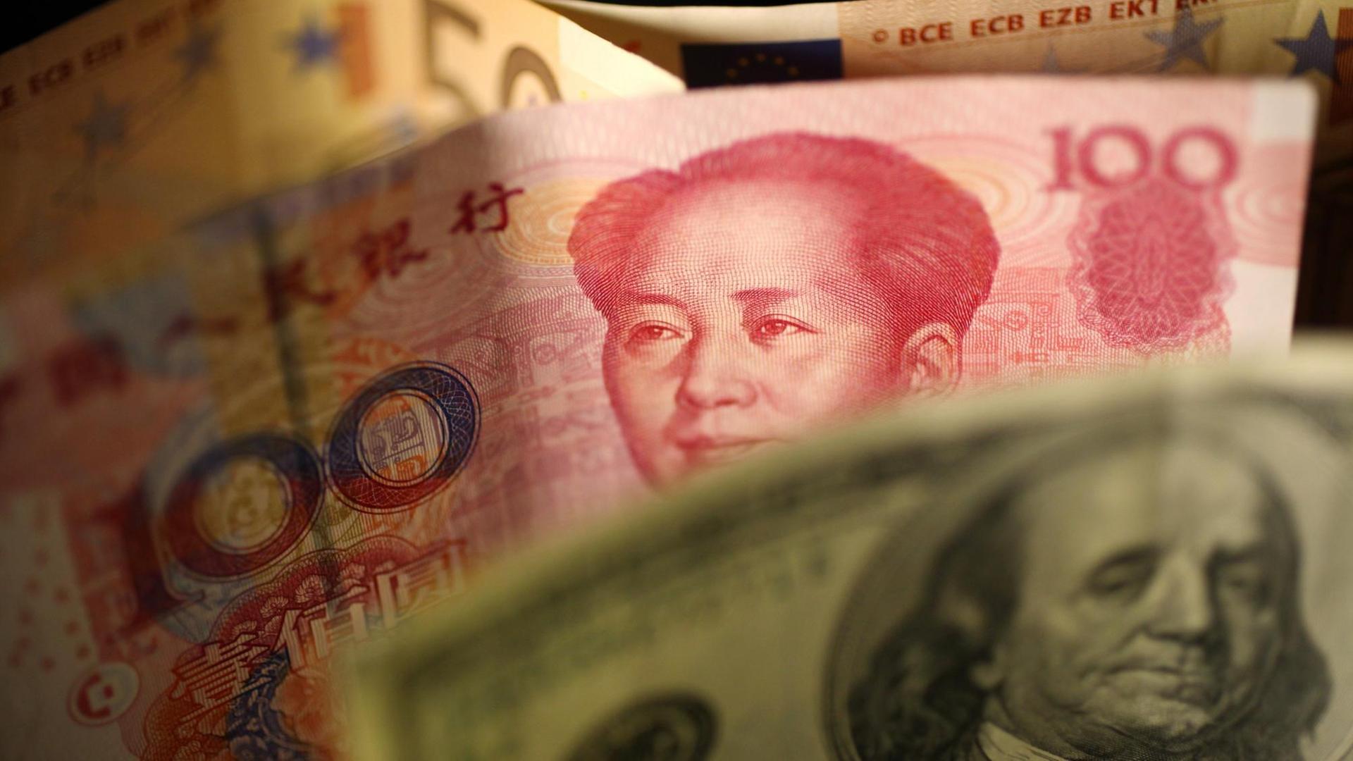 Jeweils ein Geldschein der Währungen Dollar, Reminbi und Euro.
