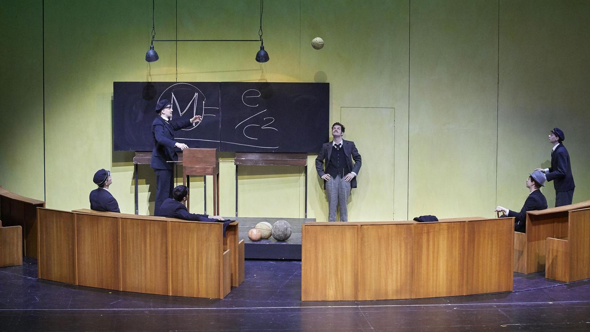 Szene aus dem Theaterstück "Die Formel" in Bern. Männer stehen und sitzen um eine mit einer Formel beschrifteten Tafel und debattieren. Szene aus dem Theaterstück "Die Formel" in Bern. Männer stehen und sitzen um eine mit einer Formel beschrifteten Tafel und debattieren.