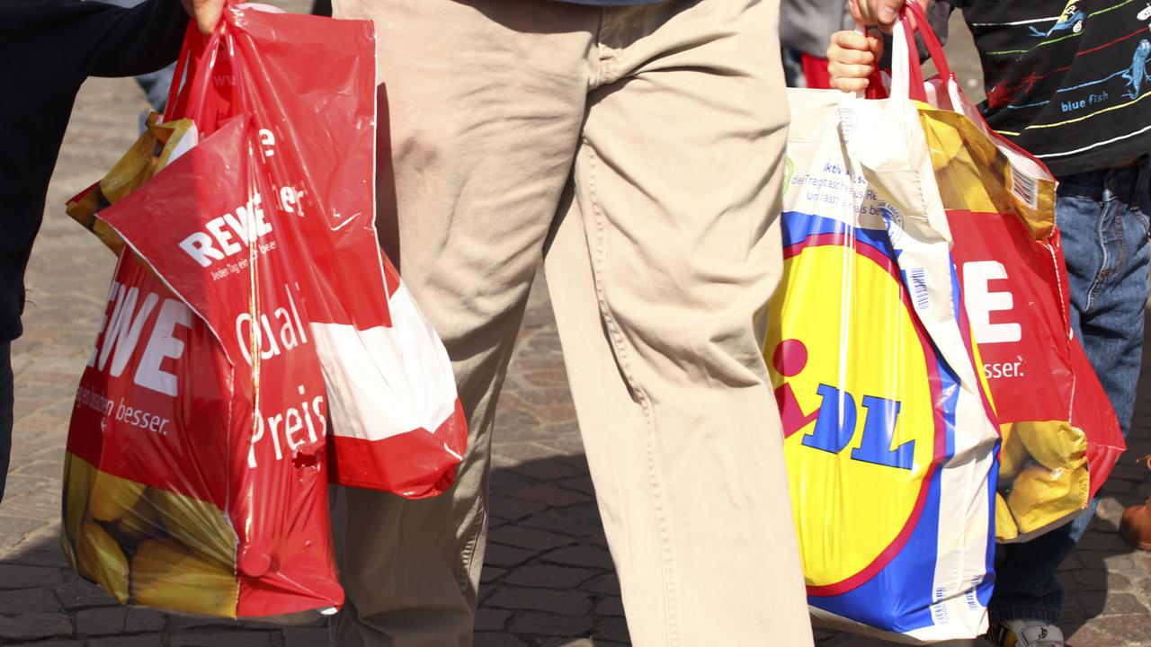 Ein Mann trägt Einkäufe in mehreren Plastiktüten