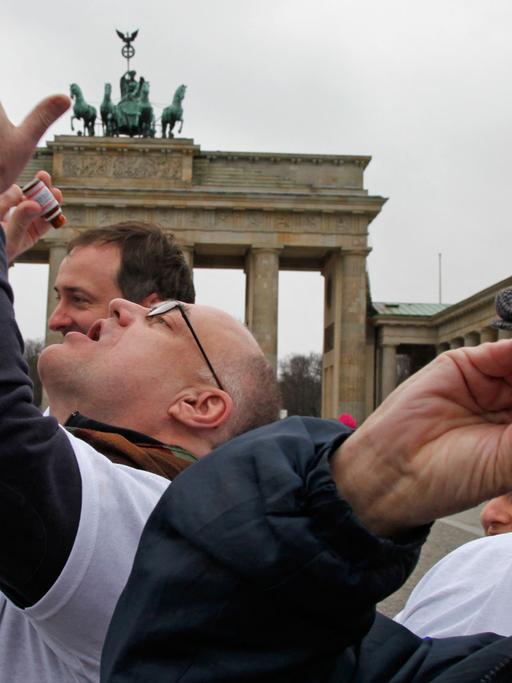 Mitglieder der "Berliner Skeptiker" schlucken im Februar 2011 in Berlin vor dem Brandenburger Tor eine "Überdosis" eines homöopathischen Mittels