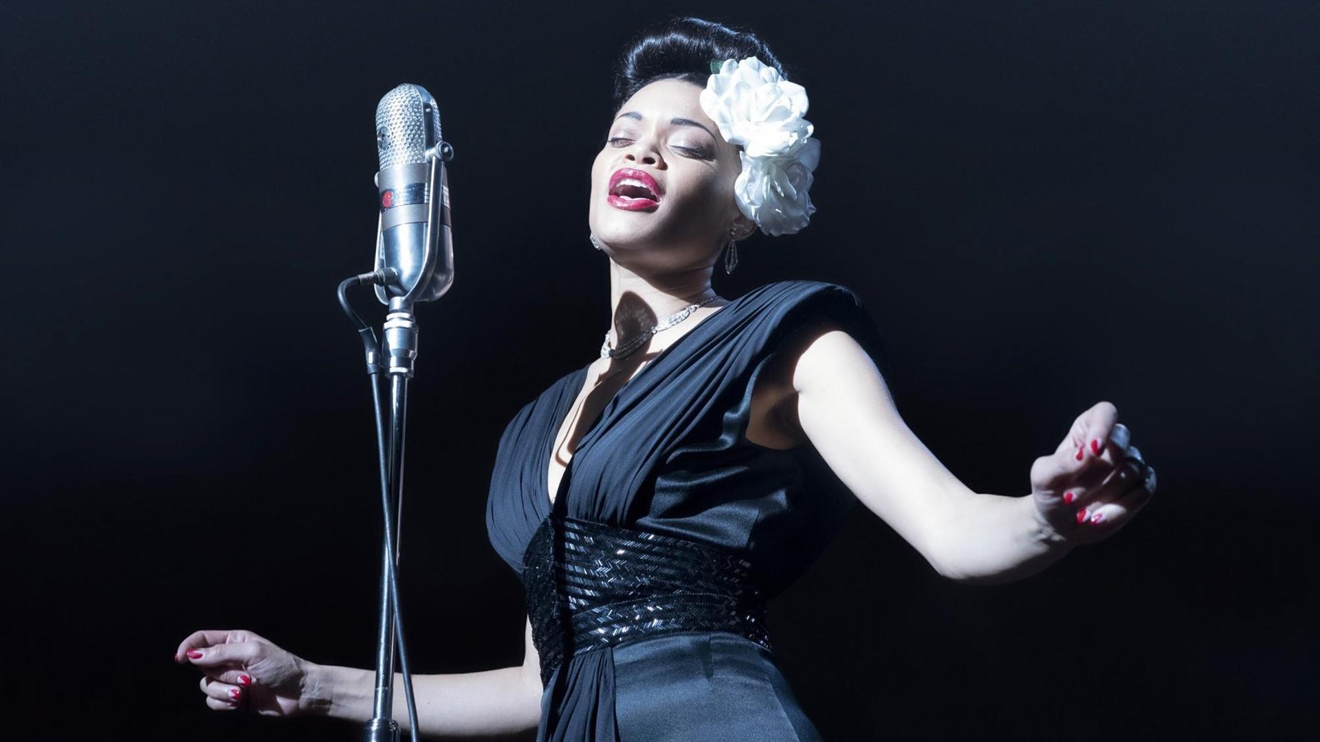 Eine elegante Jazz-Sängerin im schwarzen Kleid auf der Bühne