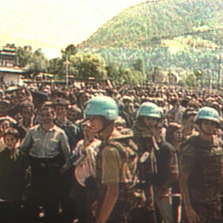 Der Screenshot vom niederländischen Fernsehen zeigt holländische UN-Soldaten in Potocari, Bosnien-Herzegowina, vor hunderten von moslemischen Zivilisten, die aus dem nahegelegenen Srebrenica vor serbischem Terror geflüchtet waren.
