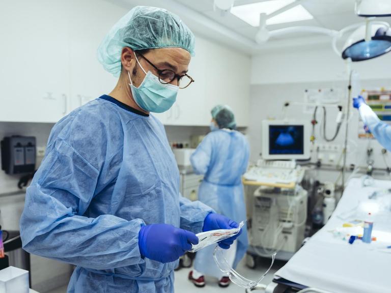 Blick in einen OP Raum mit Ärzten in Schutzkleidung