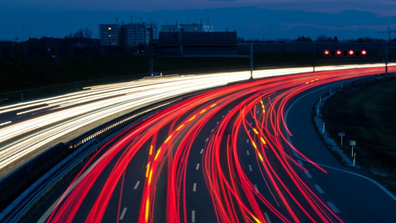 Eine Autobahn bei Nacht mit roten und gelben Lichtspuren von fahrenden Autos. Eine Autobahn bei Nacht mit roten und gelben Lichtspuren von fahrenden Autos.