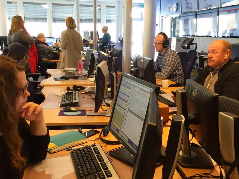 NorwegischeJournalisten sitzen in einem Großraum-Büro vor ihren Computern