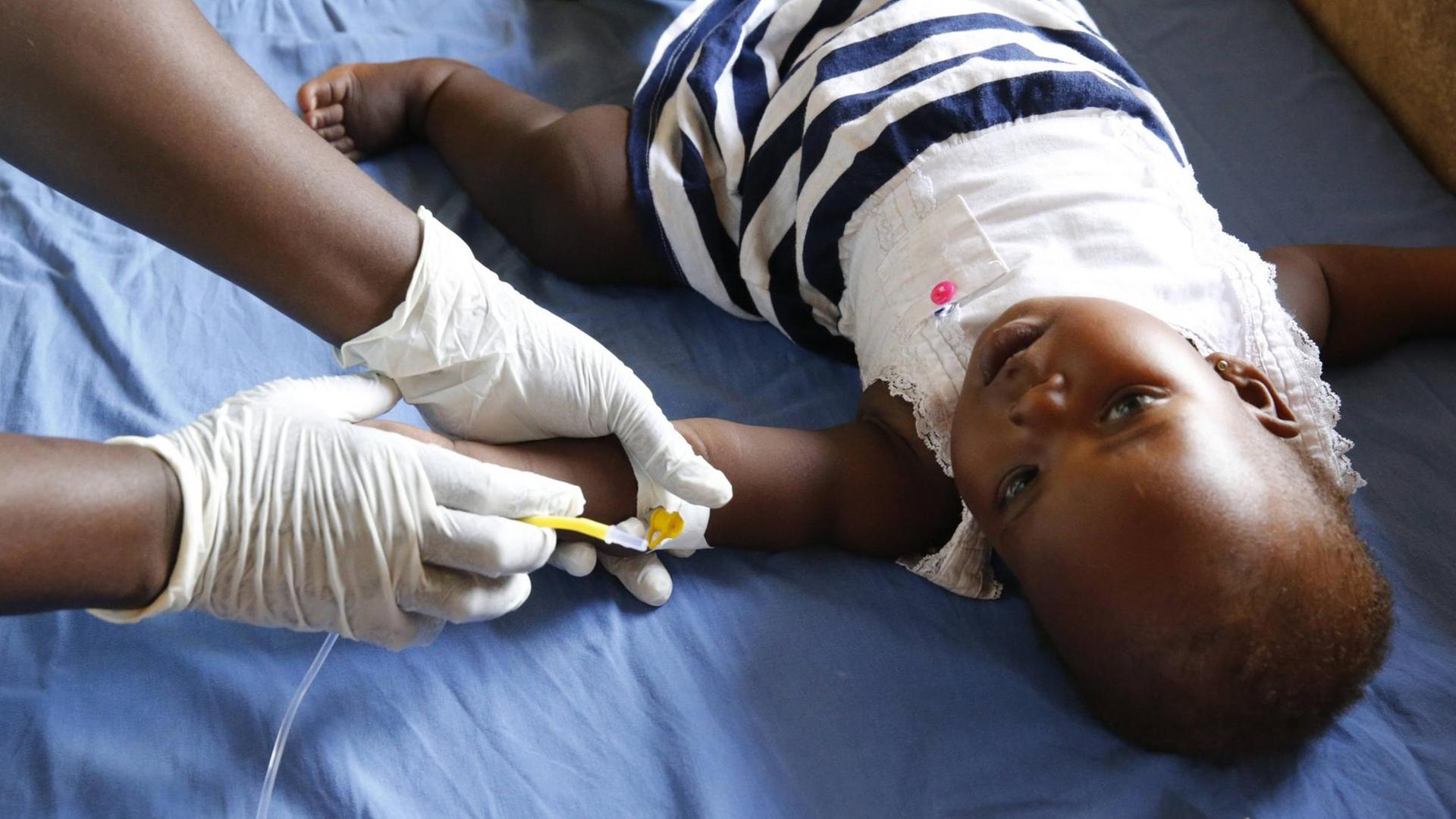 In dem Land Uganda wird ein Kind behandelt, das Malaria hat. Man sieht das Kind, das gerade eine Spritze bekommt.