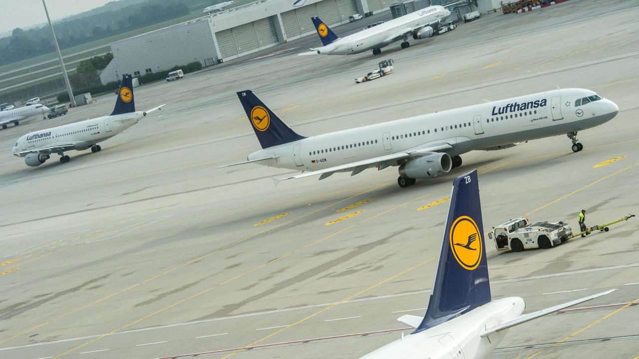 Flugzeuge der Airline Lufthansa stehen auf dem Rollfeld des Flughafen in München.