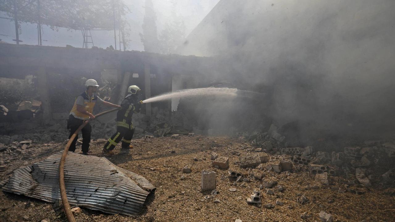 Feuerwehrmänner in Jadraya nahe Idlib löschen ein Feuer, das Berichten zufolge von russischen Luftangriffen verursacht wurde.