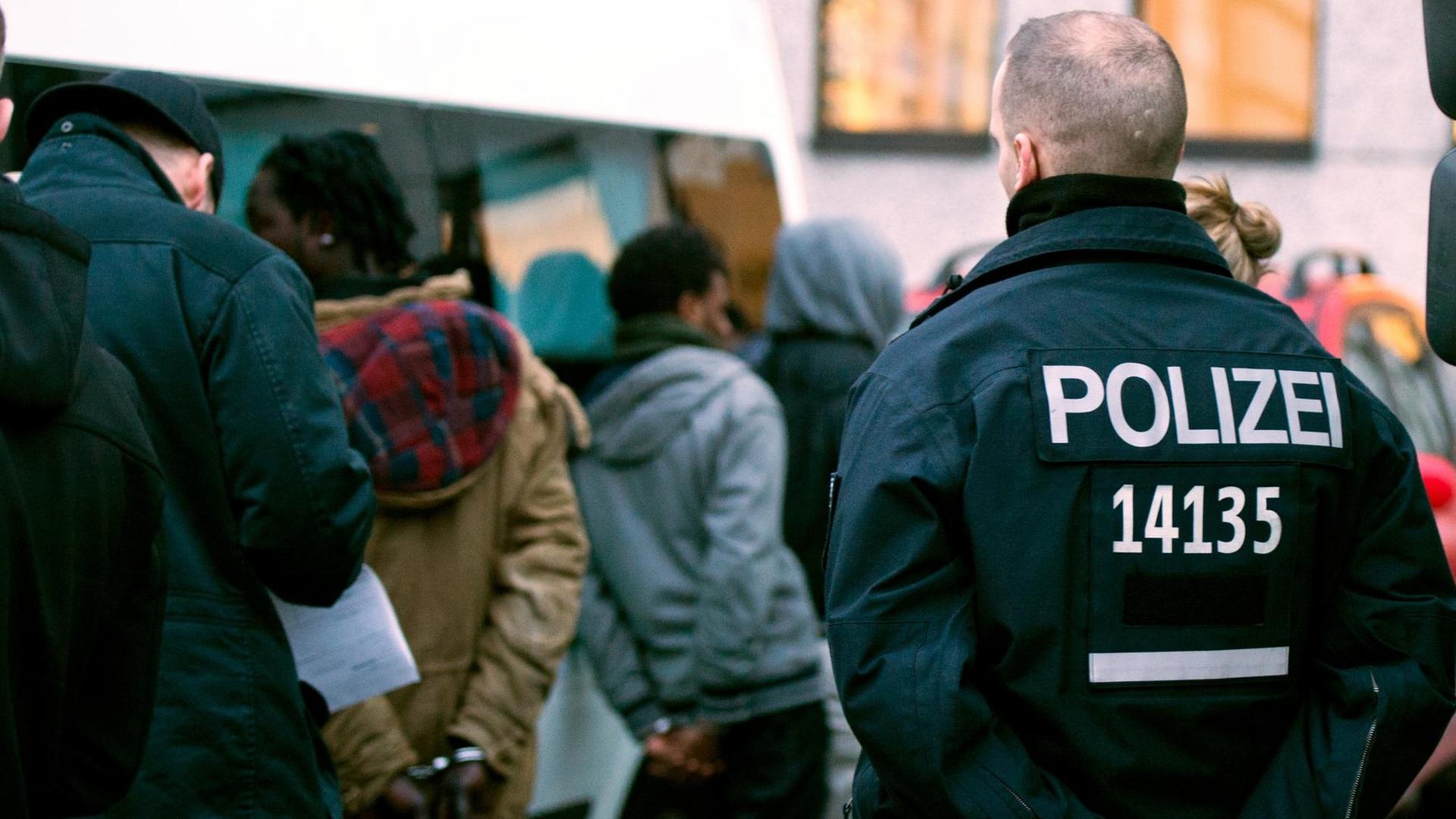 Polizisten führen nach einer Razzia im Görlitzer Park in Berlin im Bezirk Kreuzberg vorläufig festgenommene, mutmaßliche Drogenhändler in Handschellen ab, aufgenommen 2014