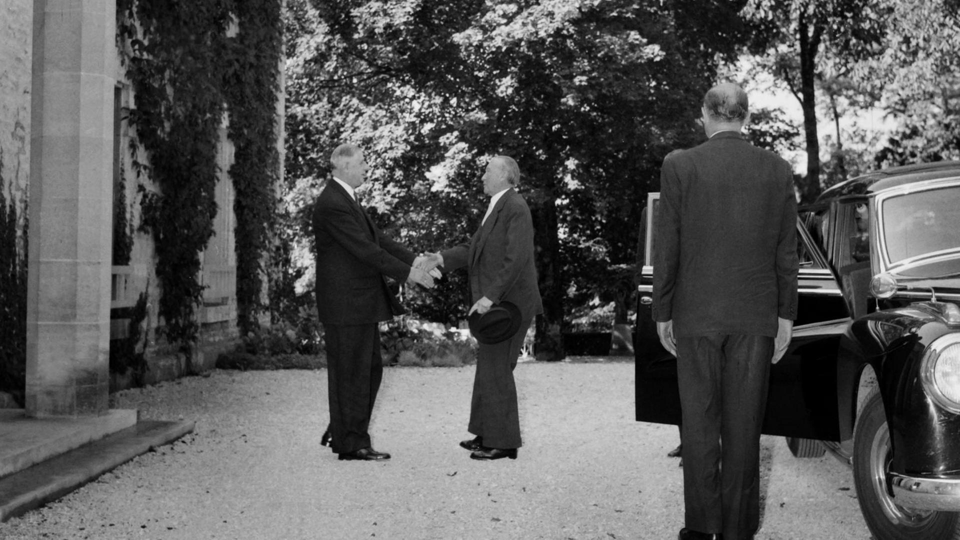 West German chancellor Konrad Adenauer (L) and French president Charles de Gaulle (C) shake hands in front of "la Boisserie", de Gaulle's home, in Colombey-les-Deux-Eglises on September 14, 1958 during their first meeting. AFP PHOTO / AFP PHOTO / INTERCONTINENTALE / -