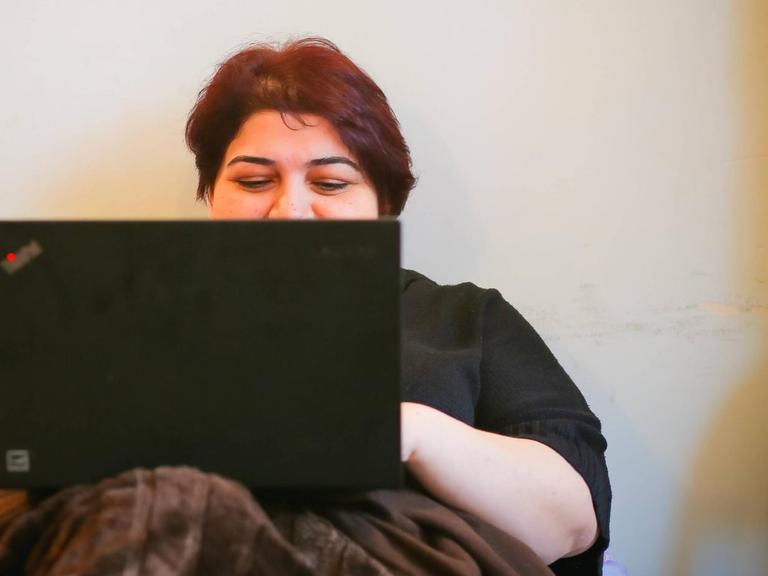Khadija Ismayilova liegt in einem Bett und tipp in ein Notebook