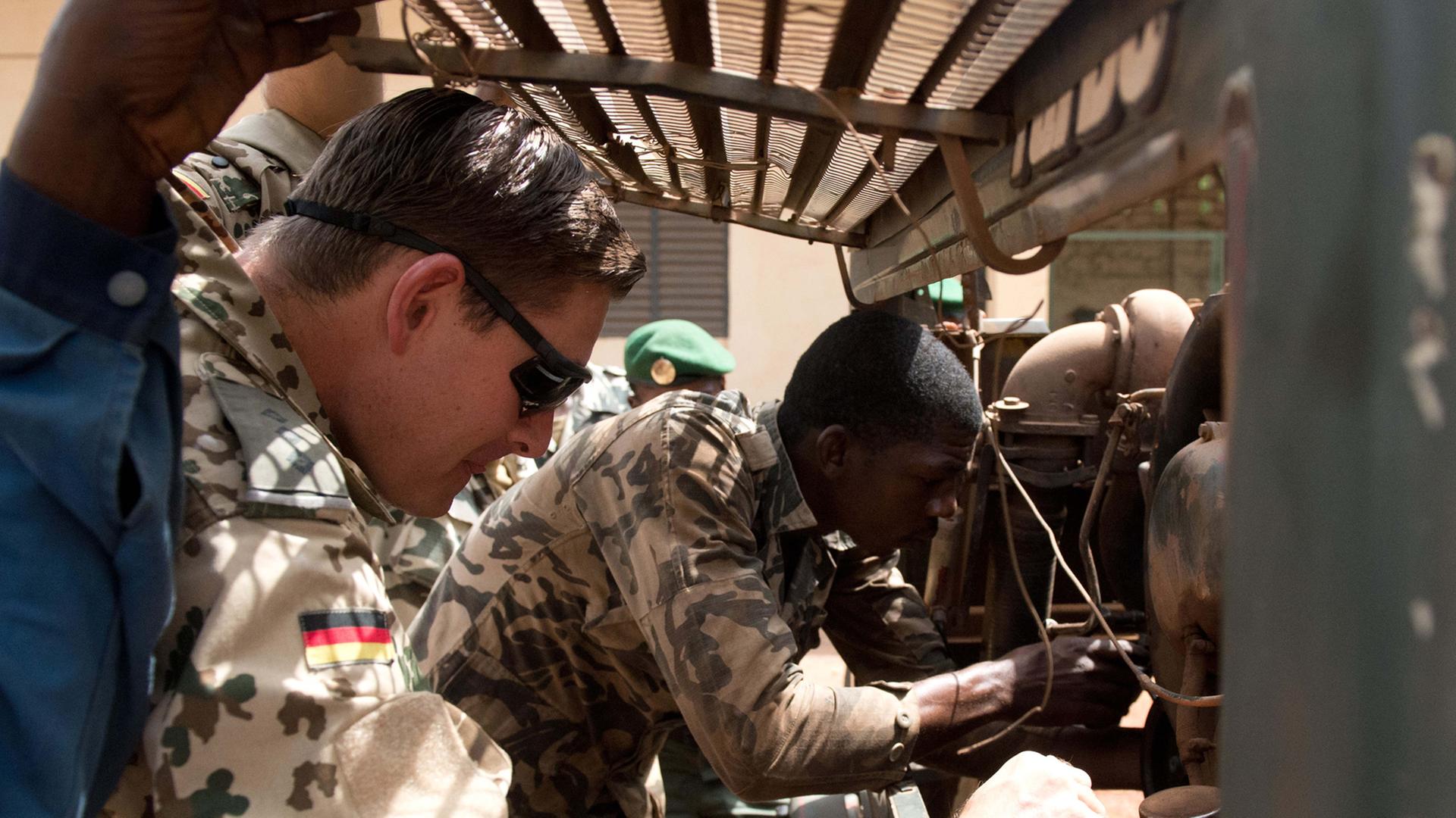 Ein Bundeswehrsoldatet bildet Soldaten in Mali aus, hier: einen KfZ-Mechaniker