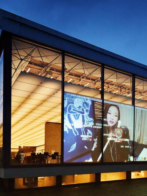Das Lehmbruck Museum von außen, auf der Glasfassade ist eine projezierte Filmszene von Xu Bing zu sehen
