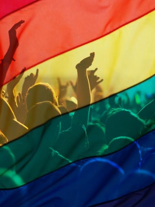 Teilnehmer einer Schwulen- und Lesbenparade mit einer Regenbogenfahne, als Symbol von Liebe und Toleranz