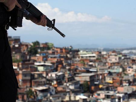 Ein Soldat zeigt mit seinem Gewehr auf die Favela El Aleman in Rio de Janeiro