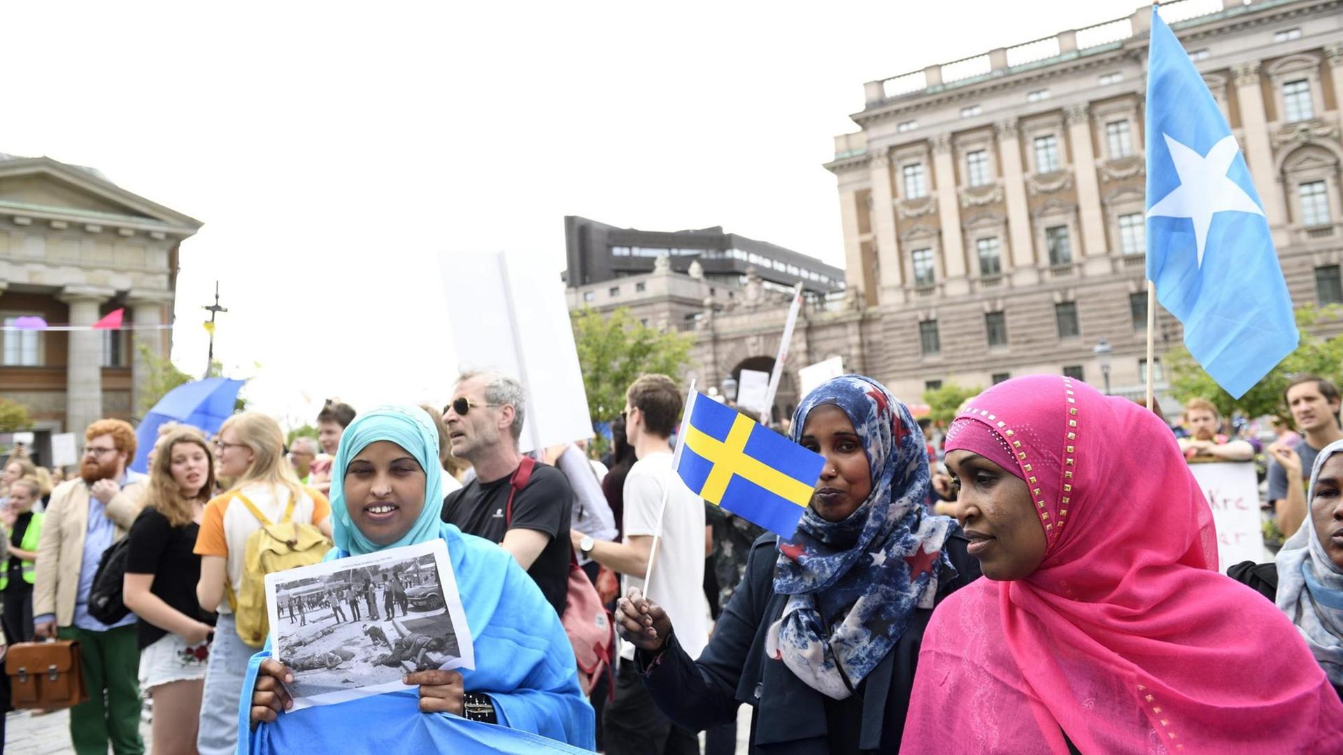 Demonstranten vor dem Schwedischen Parlament in Stockholm protestieren gegen Einschränkungen im Familiennachzug von Flüchtlingen - am 21. Juni 2016. Eine Frau hält ein Foto ihrer Angehörigen.