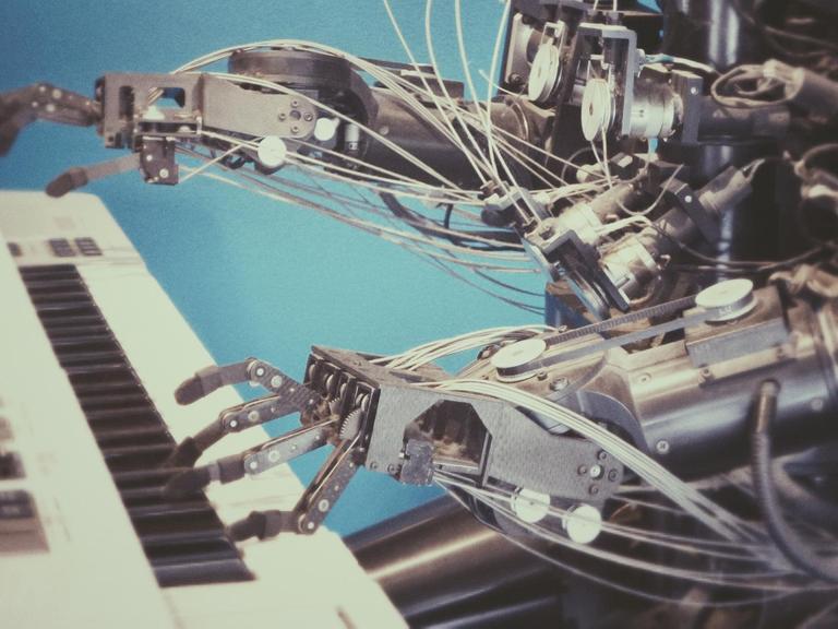 Ein Roboter spielt auf einem Keyboard.