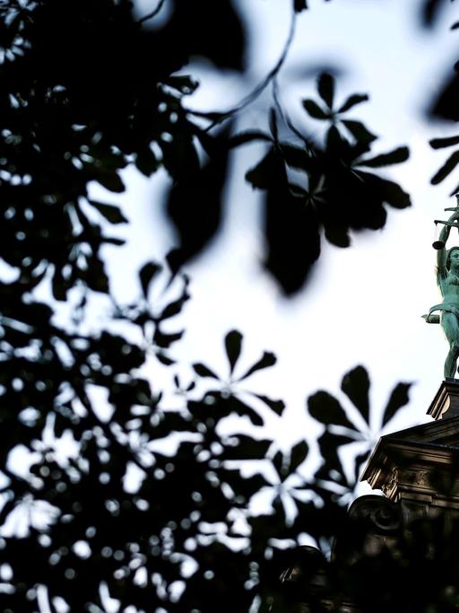 Eine Statue der Justitia haelt am 09.09.2014 auf dem Giebel des Justizgebaeudes in Bamberg (Bayern) Waage und Schwert.